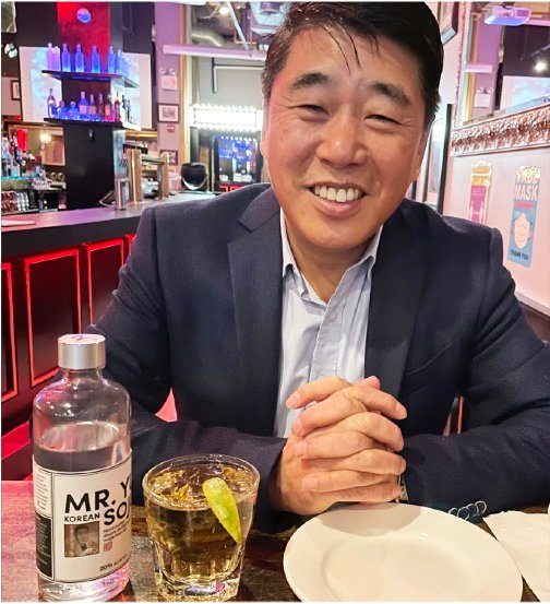 Mr. Yu at a Korean restaurant with a bottle of MR.YU Premium