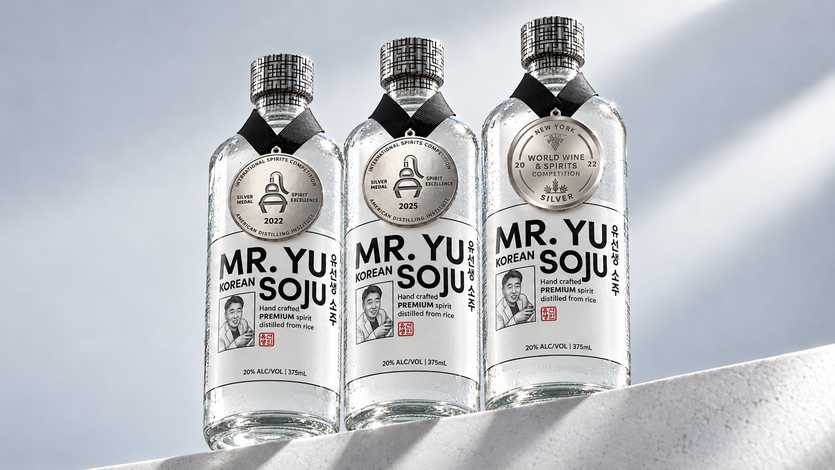 Three bottles of MR.YU Premium soju wearing their ADI 2022, ADI 2025 and New York World Wine & Spirits 2022 silver medals